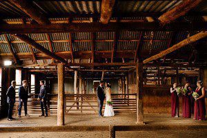 bridal party in the woolshed at Kimo Estate. Old timber poles and timber slats with corrugated iron walls