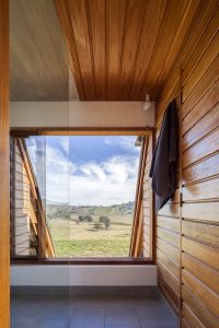 bathroom with sustainable timber and lots of glass allowing views from the shower of the off grid cabin