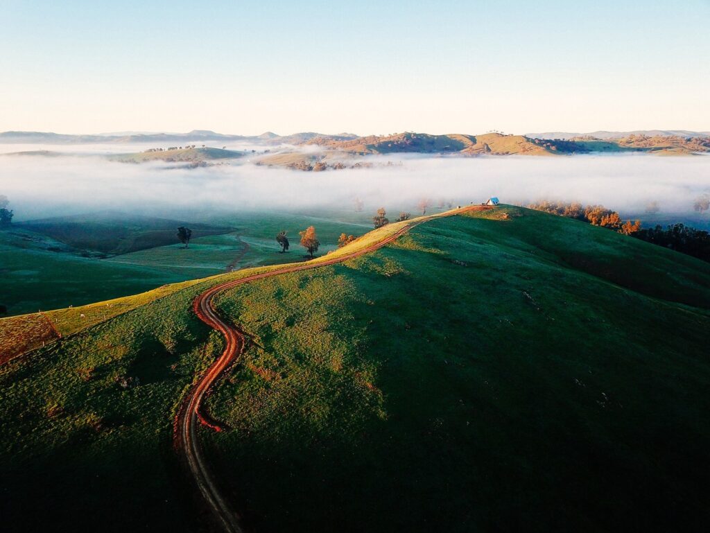 A winding track up to a little off-grid cabin on a hill with incredible views