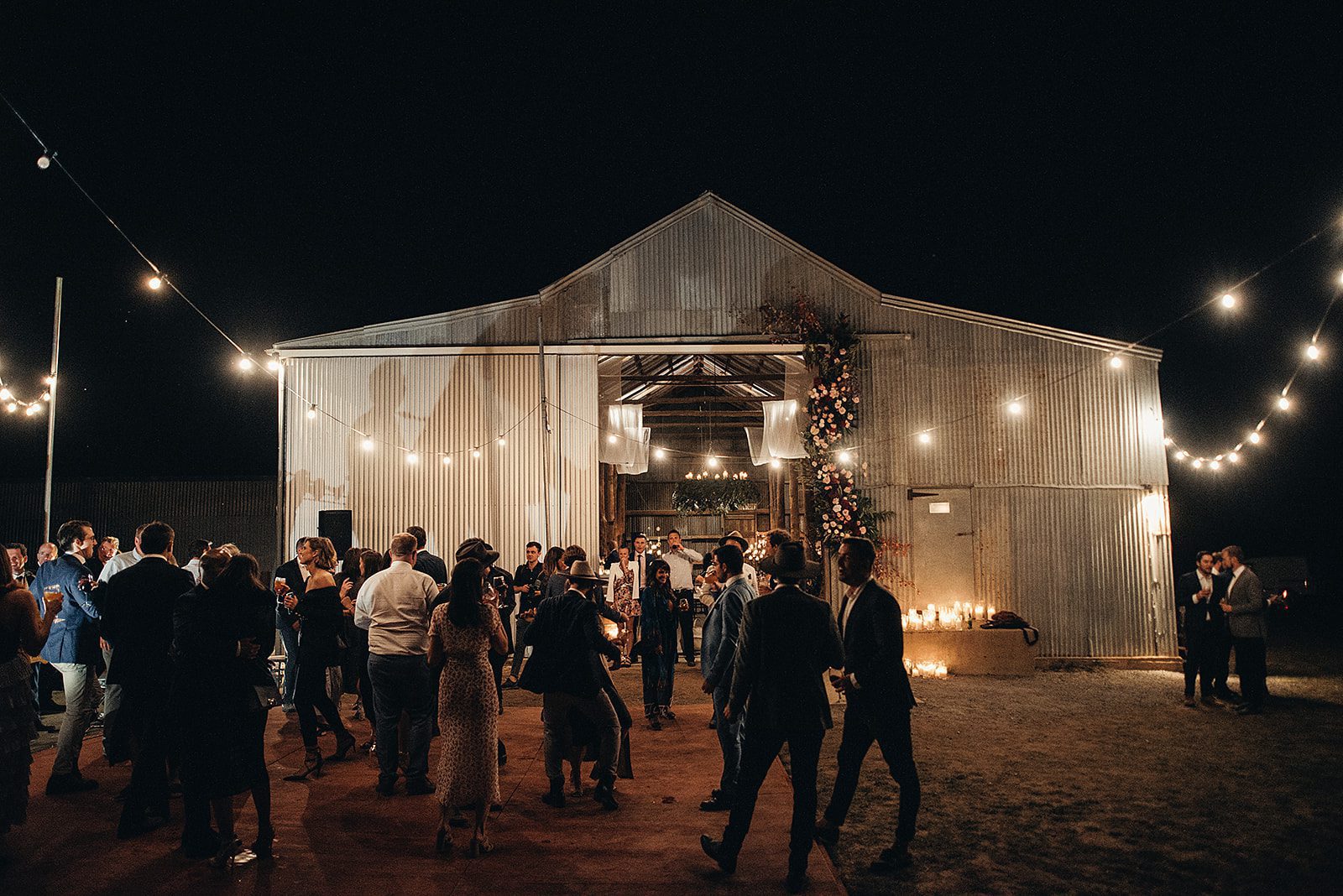 Barn Wedding Venue on a farm in country NSW. Wedding guests dance under festoon lights in the night.