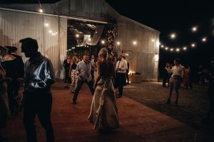 The bride dances with her dad at a Barn Wedding Venue on a farm in country NSW under festoon lights at night.