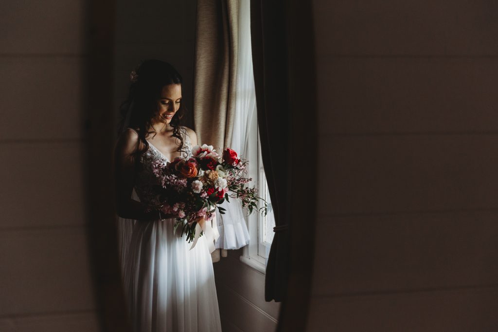 A beautiful bride bathed in window light prior to her wedding.
