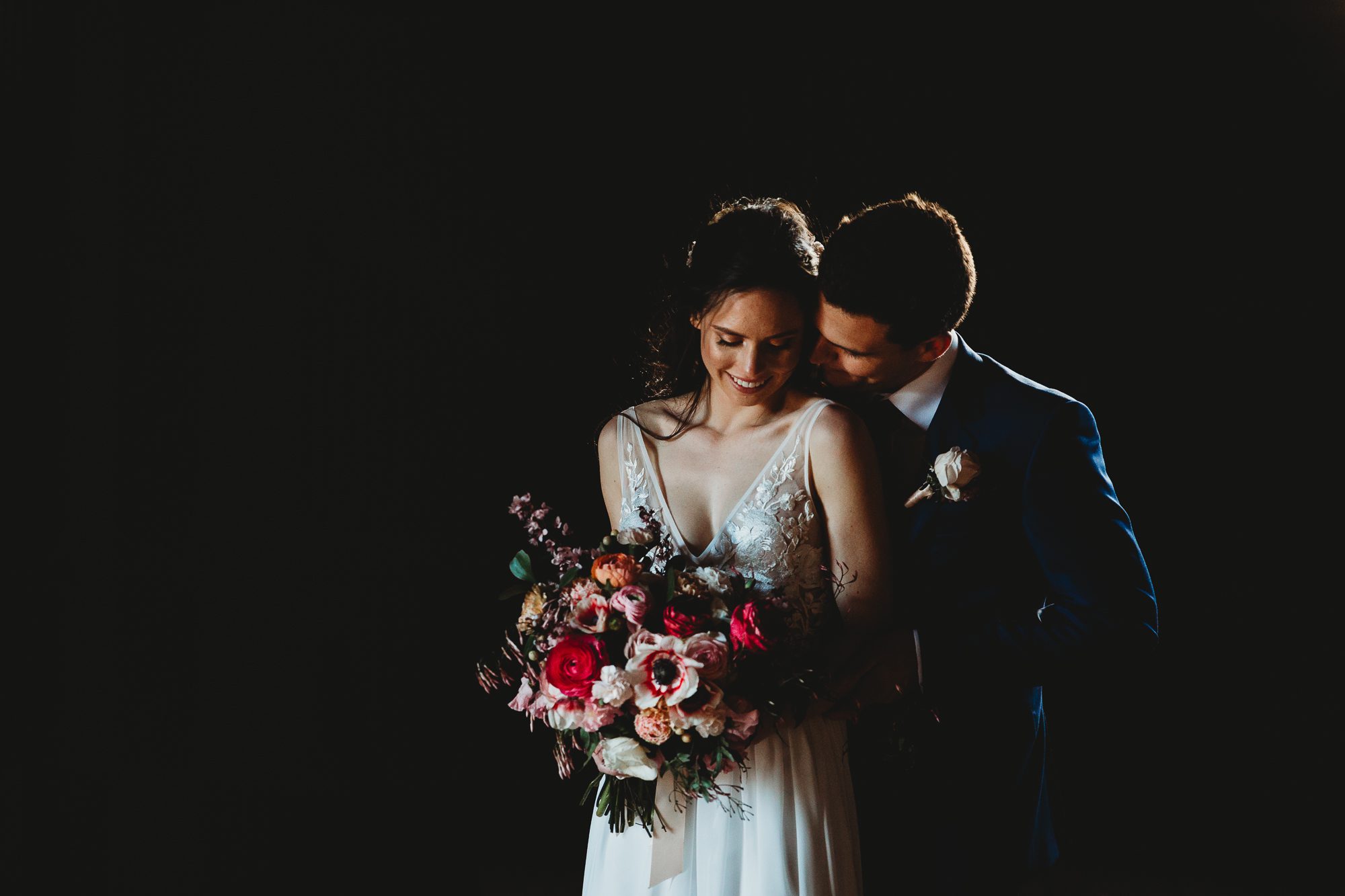 wet weather photographs from Kimo Estate wedding. The woolshed creates studio type lighting for the bride and groom