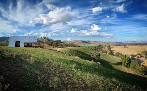 Hut on the side of a hill that is off grid looking over Kimo Estate farm