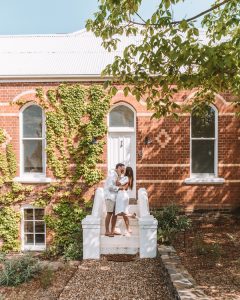 couple in front of beautiful historic building embracing and smiling 3