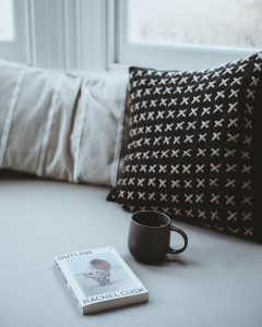 bay window seat with comfy pillows and a book and a coffee in lovely light