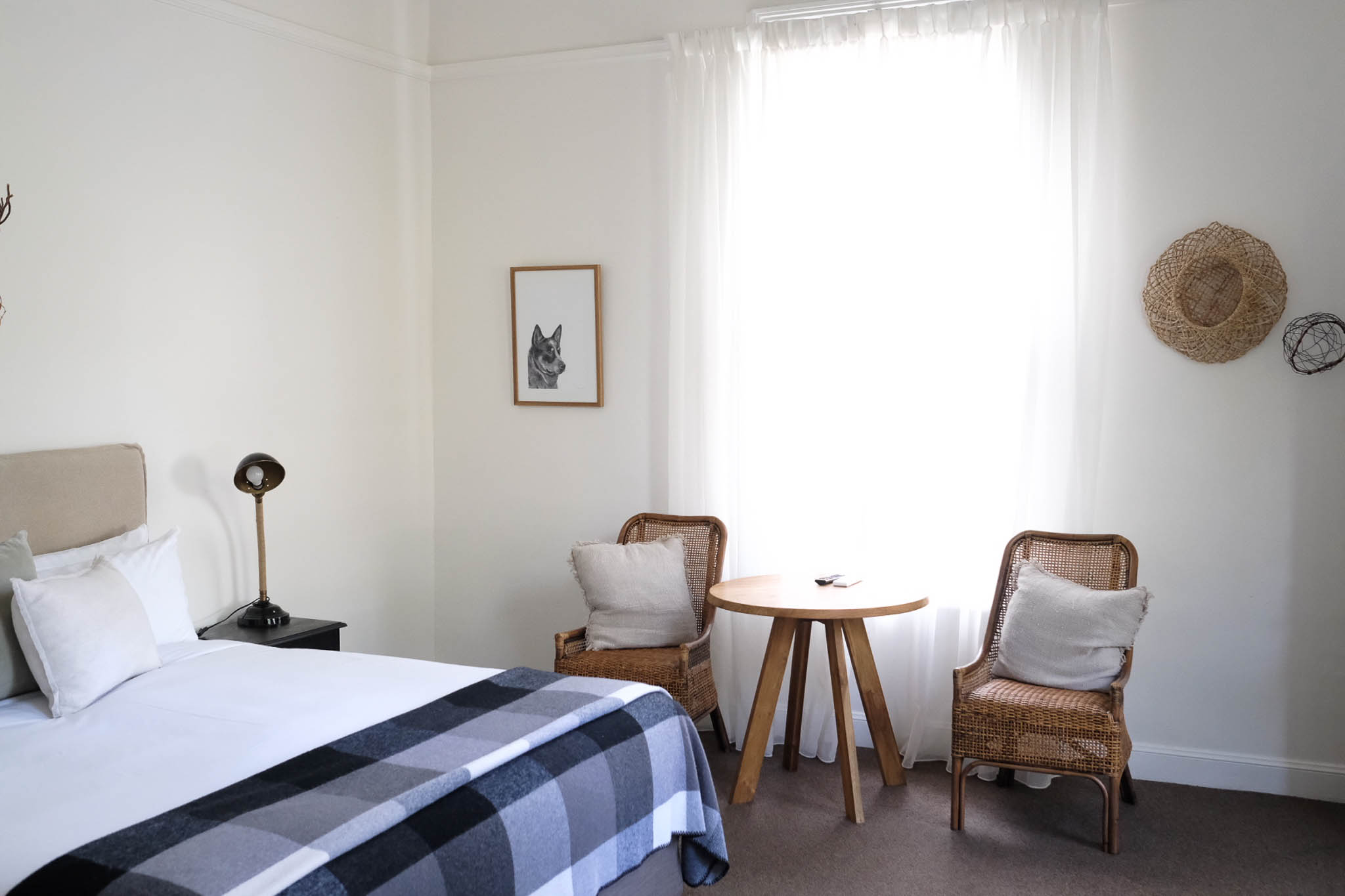 Two chairs and a king sized bed in a boutique hotel room in Gundagai
