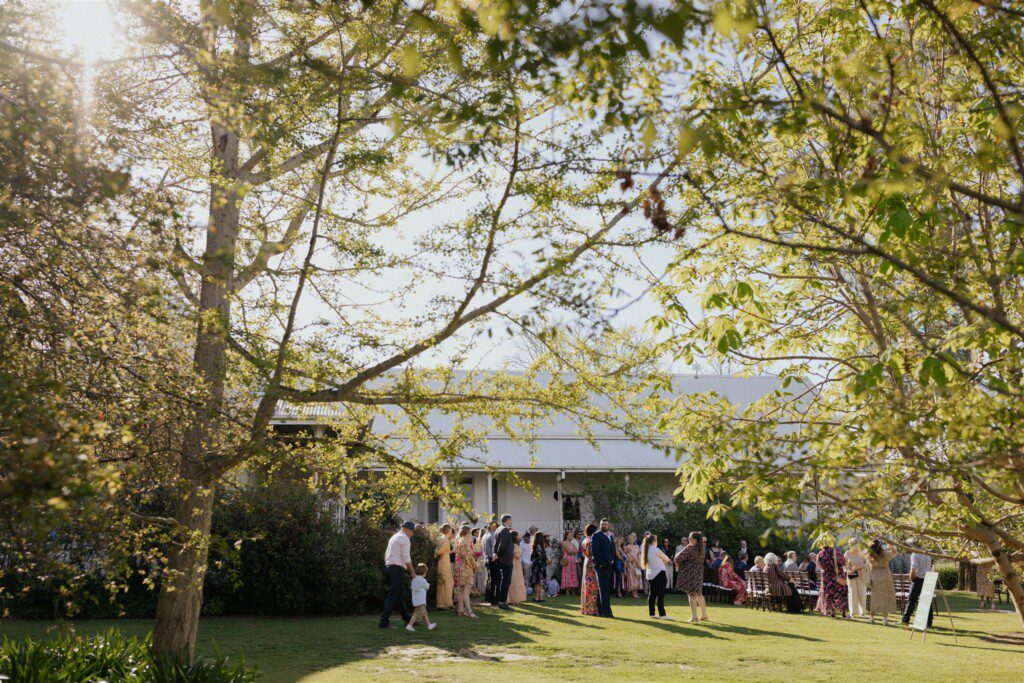 Wedding guests mill around the homestead before the ceremony