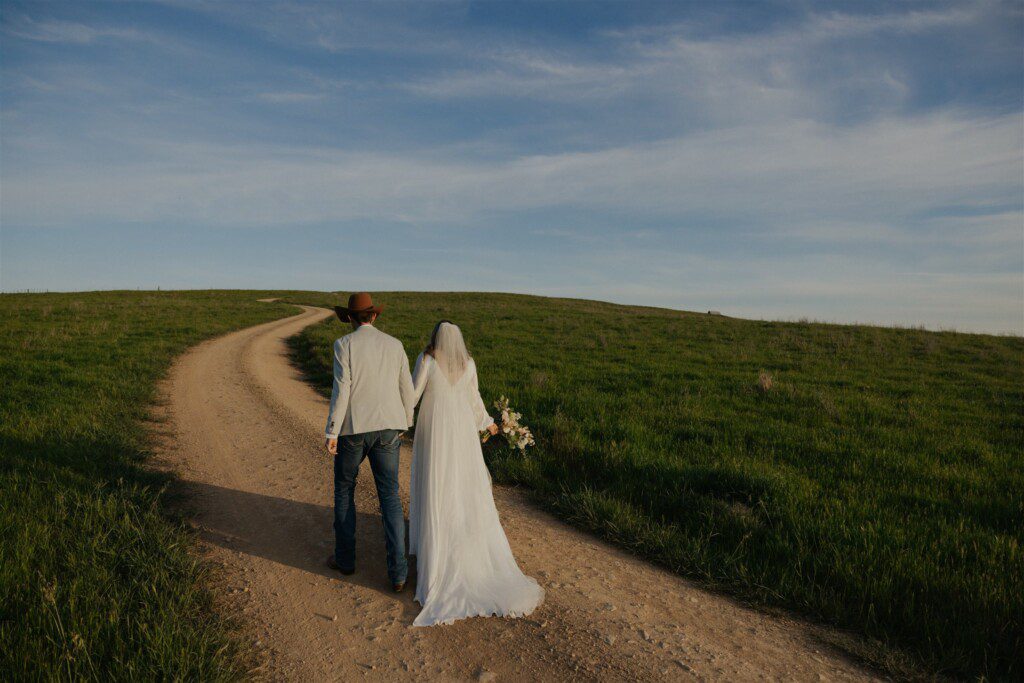 couple walking up a track on their wedding day, beginning their new life as husband and wife