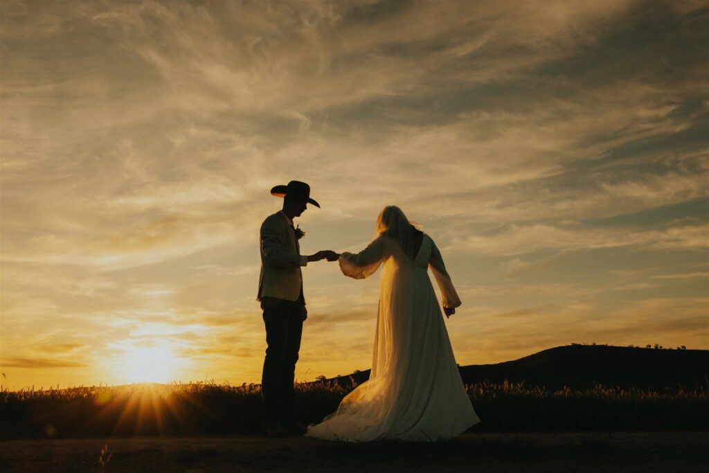 Bride and groom silhouetted against a beautiful sunset