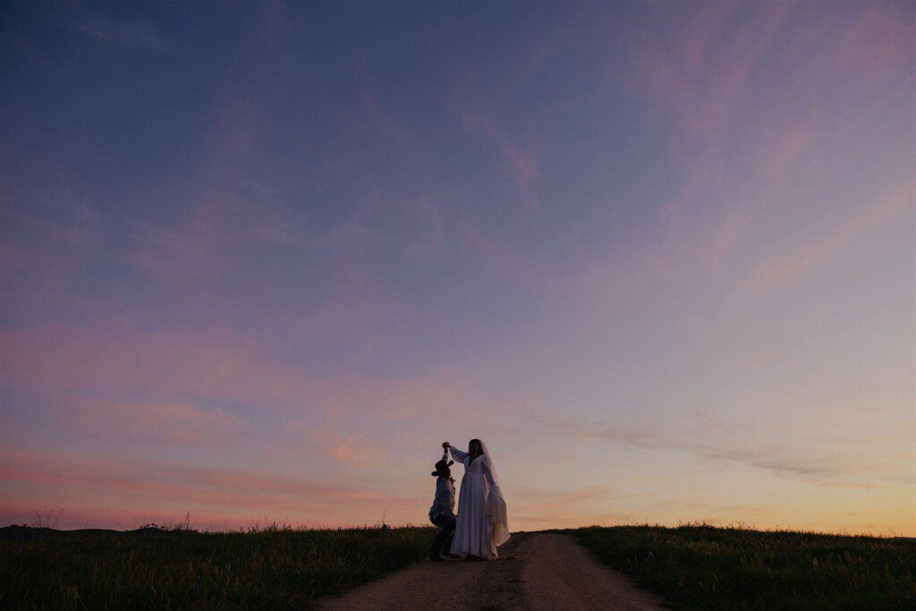 bridal couple on the horizon with a big purple sky