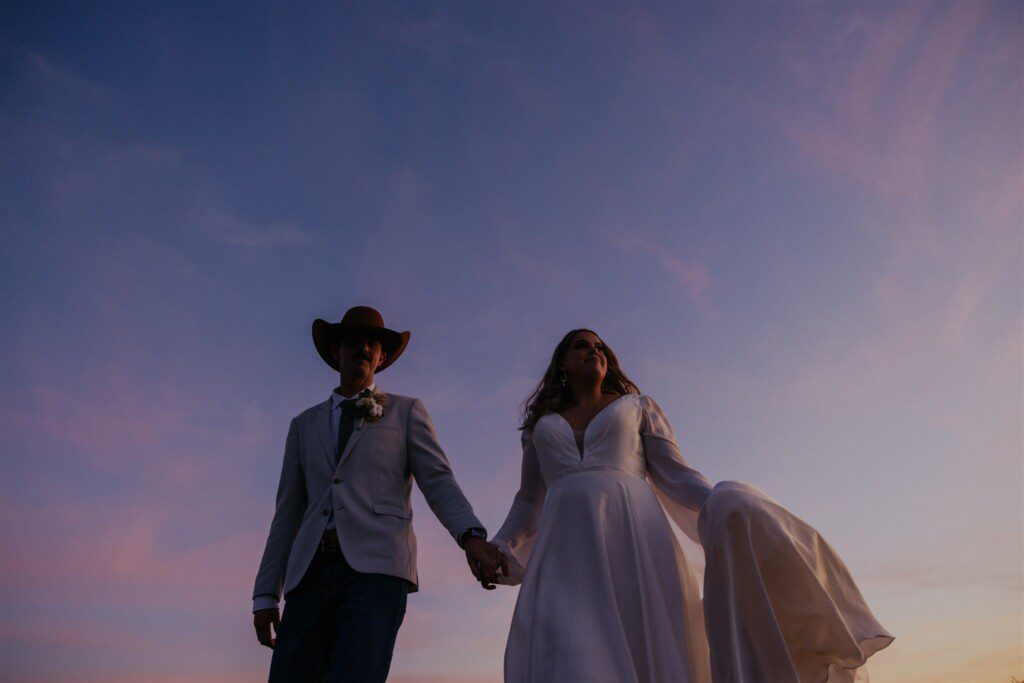 bridal couple on the horizon with a big purple sky close up